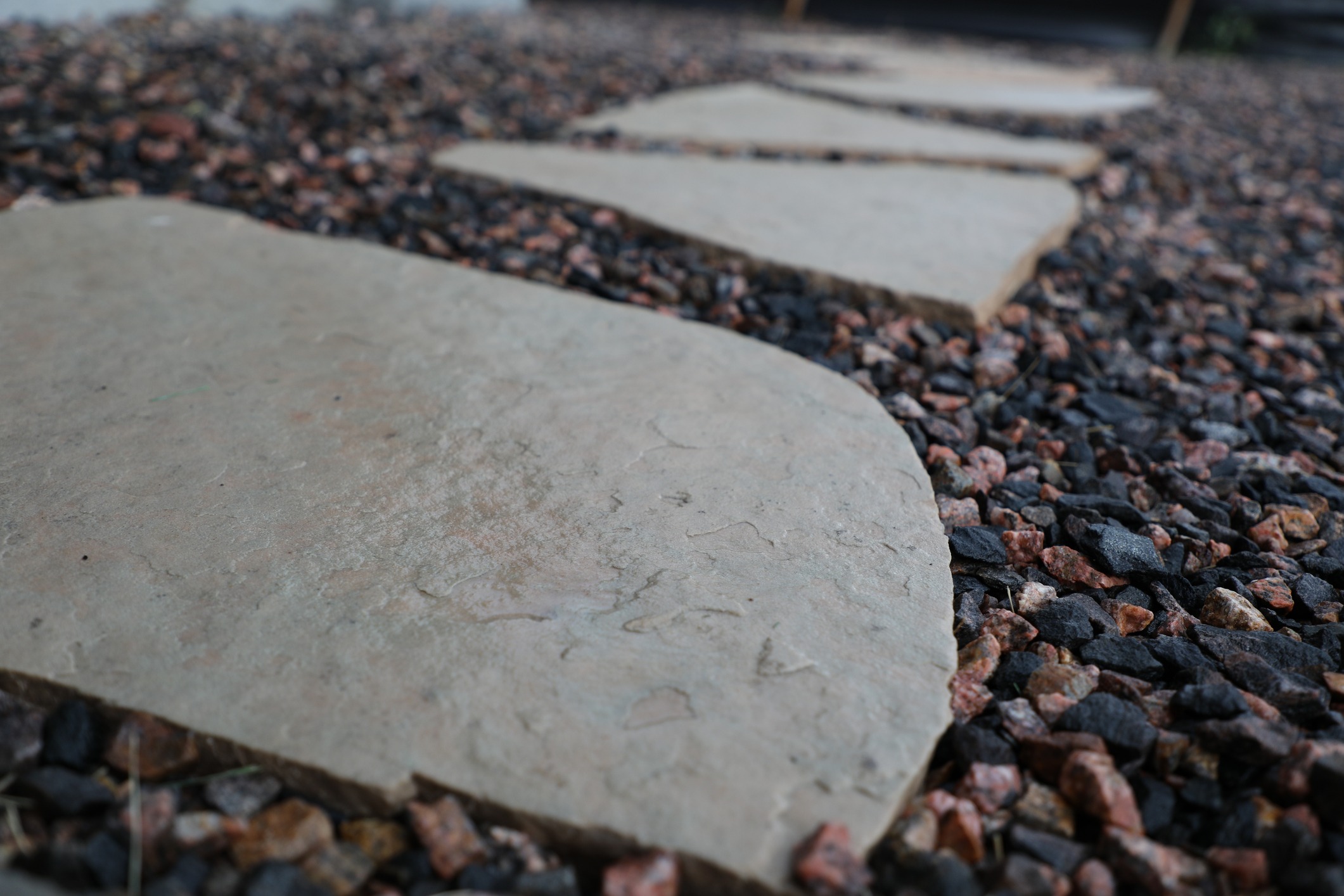 Close-up of flat limestone stepping stones surrounded by crushed granite aggregate.